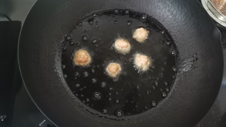 糖醋肉丸,热锅冷油,油温五成热放入肉丸炸,用小火炸