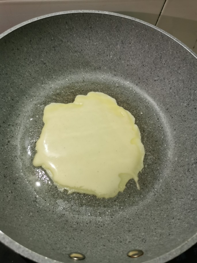 美味早餐鸡蛋饼,不粘锅加热,一点油,倒入鸡蛋面粉糊,快速转动锅,使面粉糊均匀的摊开。