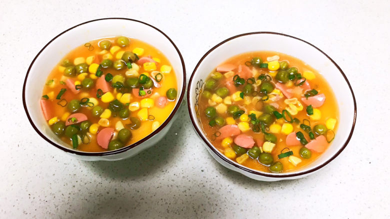 鸡蛋豆腐羹,把炒好的甜玉米青豆分别加入两个碗里,撒入香葱末,美味的鸡蛋豆腐羹就可以开吃了~