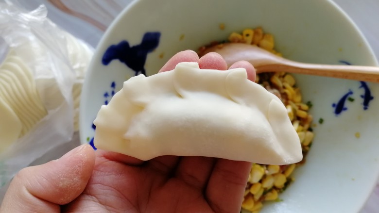 玉米猪肉饺,锁边,如果觉得面粉比较干可以抹点水在边上,然后包拢