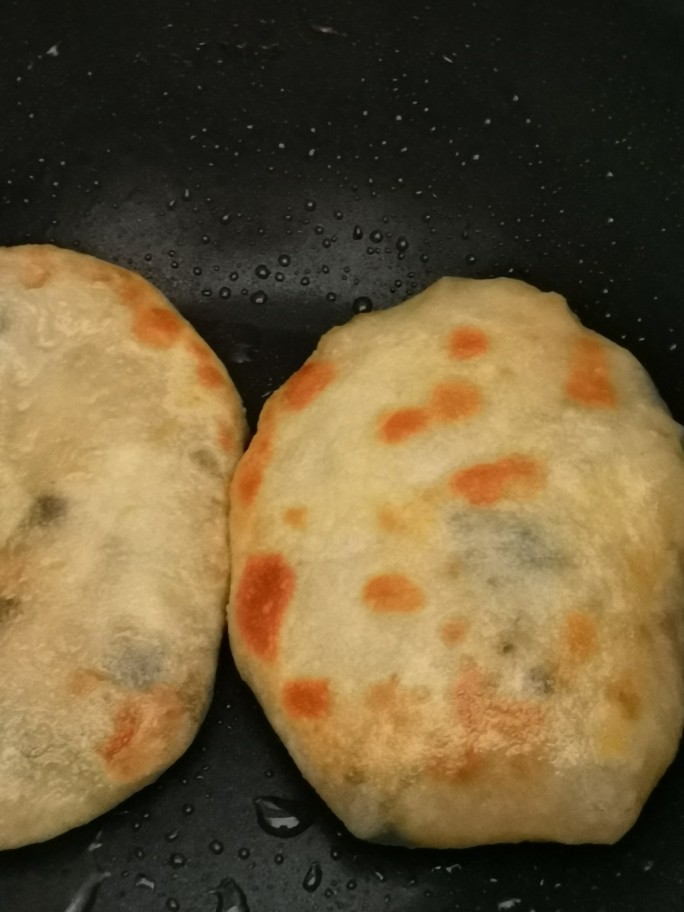 香葱猪肉馅饼,煎锅烧热落食油(油量一定要够多),饼放进去,先将一面煎金黄再翻转另一面煎金黄,担心肉馅不够熟,洒一点水加盖2分钟。