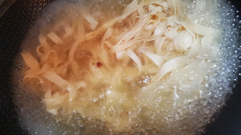 香辣豆皮,水烧开后放入豆腐皮,大约5分钟煮熟,捞出放入碗中。
