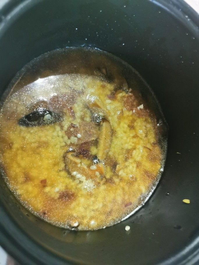 香菇腊肠焖饭,倒回电饭锅里,加入刚刚泡香菇的水,不够的话在加清水至平常煮饭的量,按下煮饭键