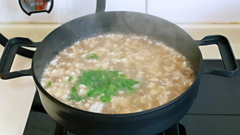 香菇豆腐汤,关火加入香菜和葱花,借助余温将其烫熟即可。