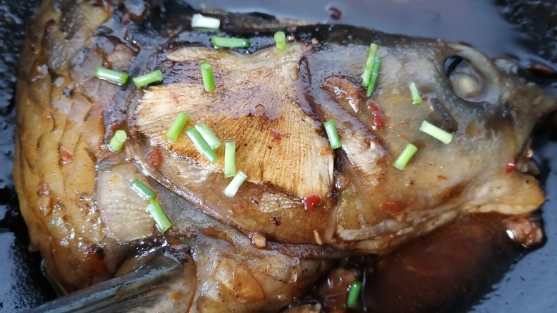 麻辣鱼头,小火炖煮至入味上色即可,撒上葱花关火。