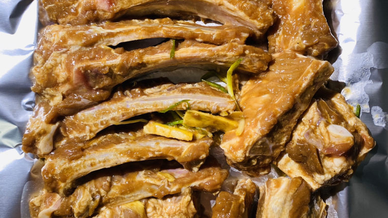 五香烤排骨,烤盘垫上锡纸,将排骨均匀的铺放锡纸上,用锡纸把排骨包裹在里面。