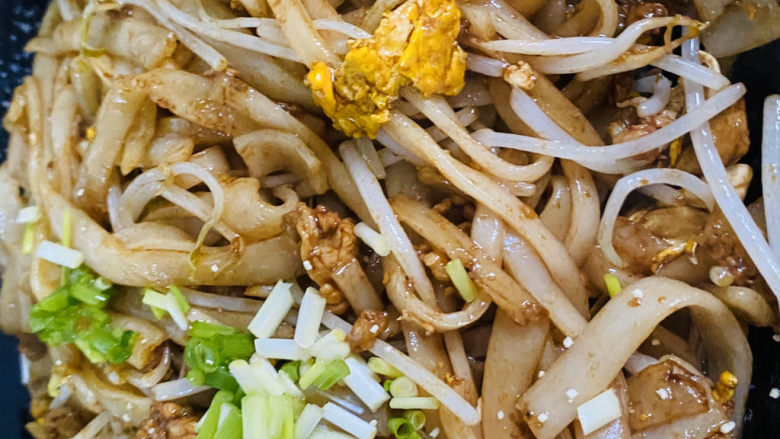 瘦肉炒河粉,撒上葱花,放入半勺鸡粉调味。
