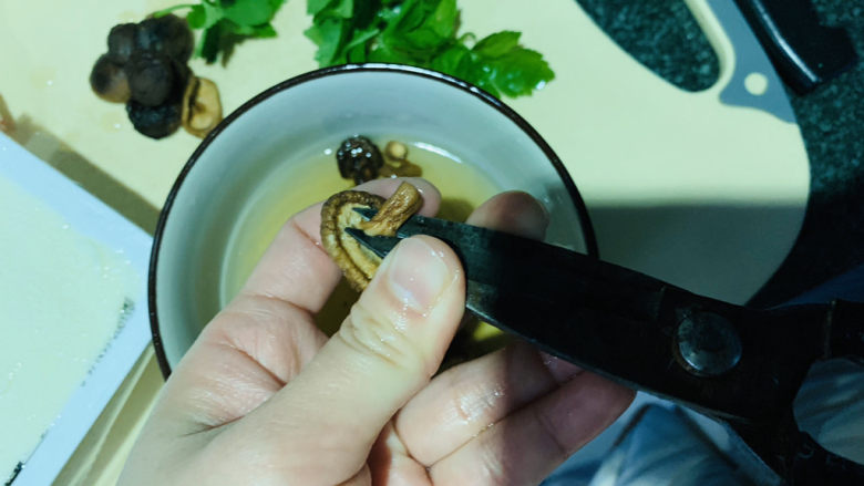 香菇豆腐汤,泡发好的香菇把根剪掉;