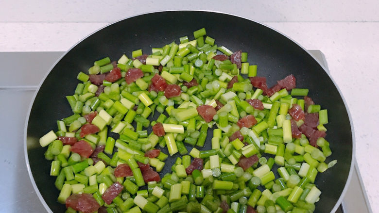 蒜苔炒腊肠,然后倒入蒜苔一起翻炒。其间要撒点开水防焦