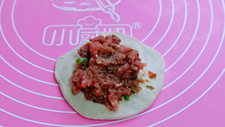 鲜肉饼,取一块面团,用擀面杖擀圆饼,放上拌好的馅。