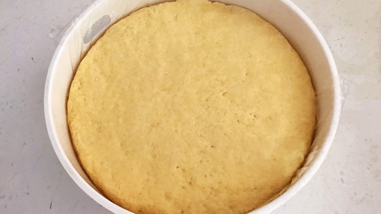 小米发糕,取一个蒸屉,里面铺好耐高温保鲜膜,然后把揉好的小米面放入蒸屉,把面团整理平整