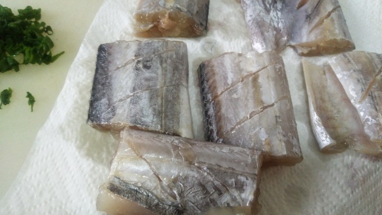 酥炸带鱼,泡好的鱼块用吸油纸吸水,免炸时飞溅