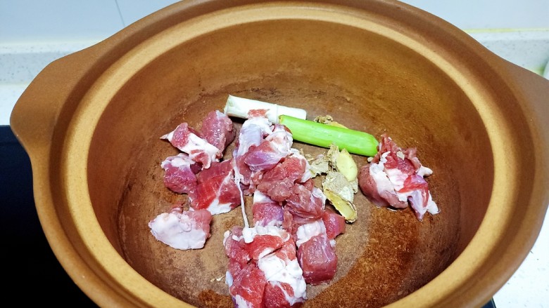 羊肉炖胡萝卜、山药、粉条,羊肉放入砂锅中,放入葱段、<a style='color:red;display:inline-block;' href='/shicai/ 37'>姜</a>片