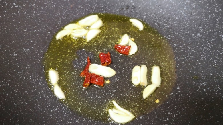 醋溜大白菜,炒锅内倒适量的食用油烧热,下入蒜片和干红辣椒炒香。