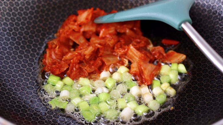 泡菜核桃蛋炒饭,爆香蒜苗白,再放入泡菜。