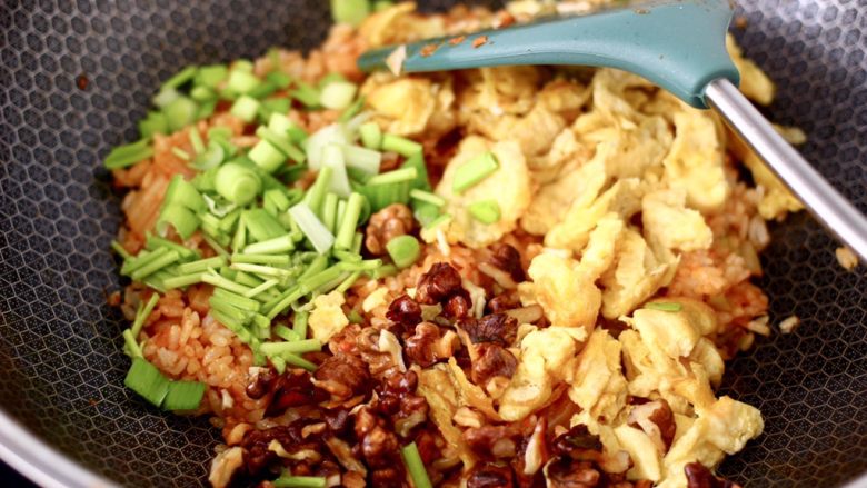 泡菜核桃蛋炒饭,这个时候加入炒熟的鸡蛋和核桃,剩下的蒜苗叶和香菜段。