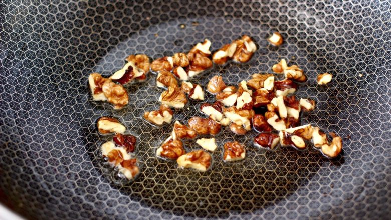 泡菜核桃蛋炒饭,另起锅烧热,倒入剩下的花生油烧热,小火炸香核桃仁。