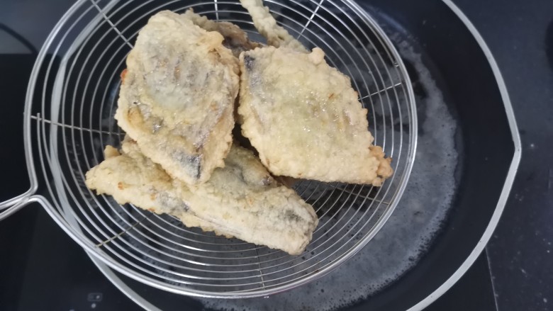 酥炸带鱼,炸至微黄捞出,稍凉用大火复炸一下,大约十秒就可以了