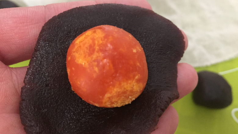 蛋黄酥,取红豆沙包裹蛋黄并搓圆，蛋黄和豆沙一共约40g
