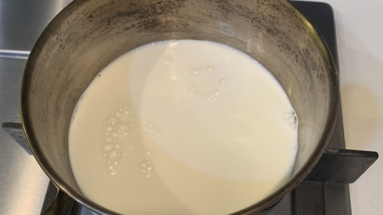 姜汁撞奶,锅里倒入牛奶,小火慢煮