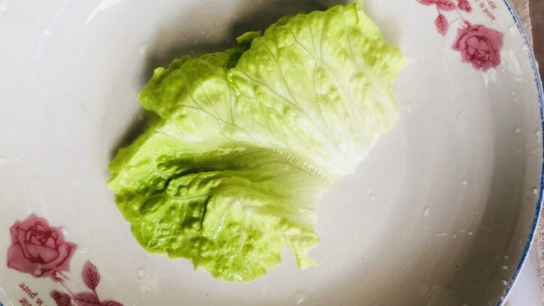 拔丝芋头,叶子择去头部,留叶片处,准备一个盘子,中间铺一片叶子。盘子要大一些