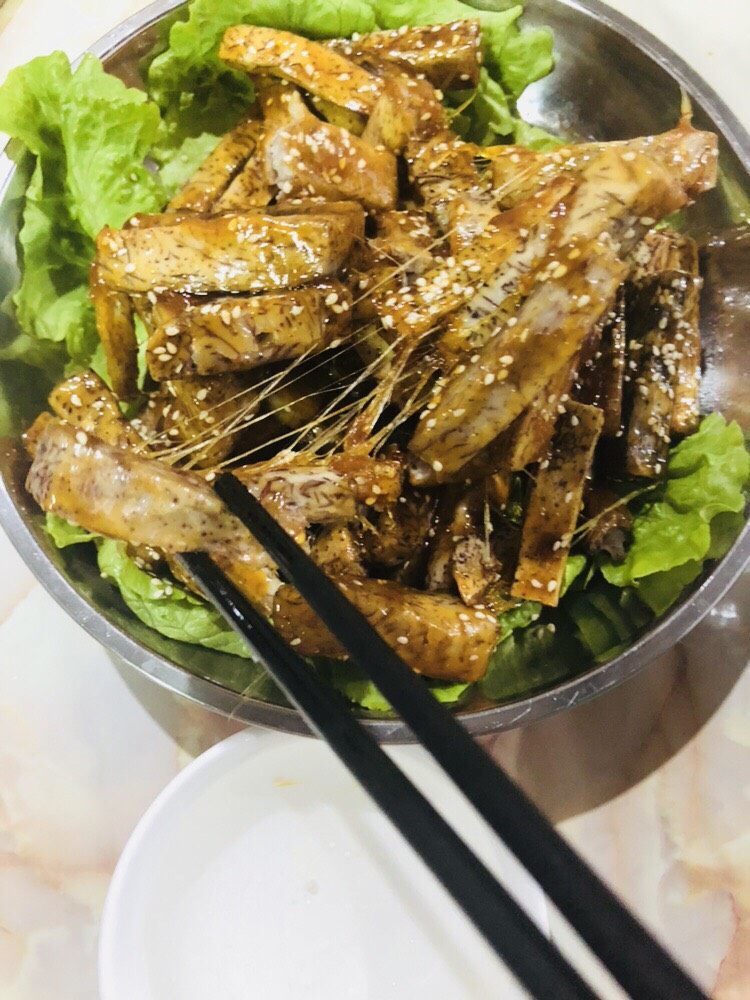 拔丝芋头,拔丝少不了一碗冷开水,夹一个芋头条,拔丝的样子。