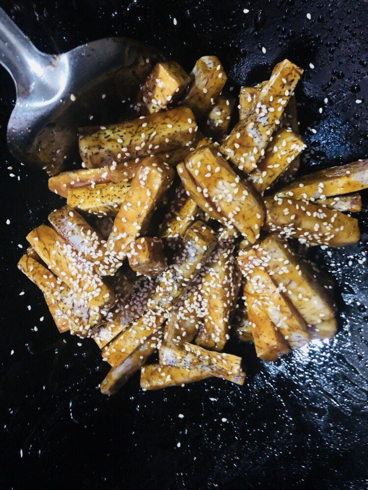 拔丝芋头,撒入芝麻,翻炒后装盘