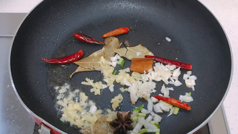 香辣草鱼,煎好鱼骨后捞起,倒入香料和葱姜蒜炒香