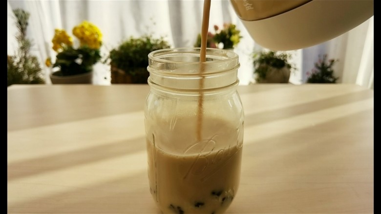 宅家自制珍珠奶茶,最后把煮好的奶茶倒入杯里,加入珍珠。