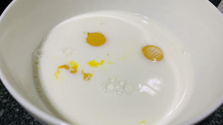 草莓蛋挞,把纯牛奶倒入装有白砂糖和蛋黄的碗中;