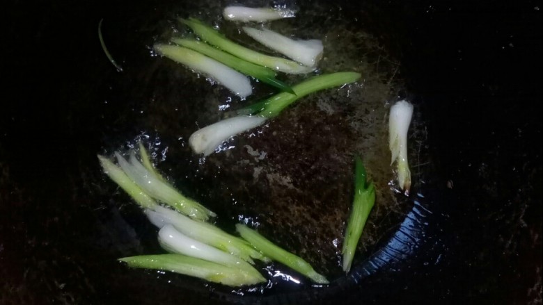 炒合菜,炒锅倒油,放入葱白段小火炒香。