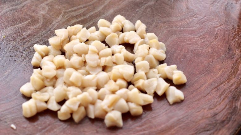 荠菜扇贝丁饺子,扇贝丁用<a style='color:red;display:inline-block;' href='/shicai/ 718'>料酒</a>腌制20分钟后,把每个扇贝丁一切两瓣。