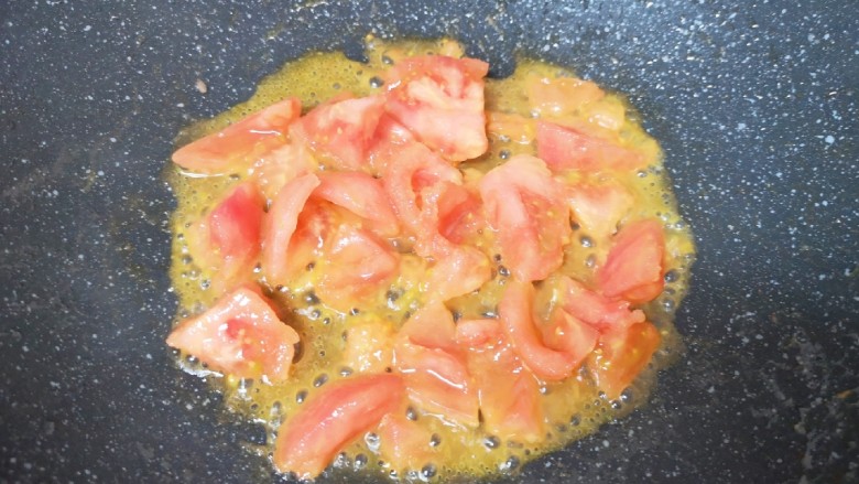 金针菇牛肉卷,炒锅内倒适量的食用油烧热,下入西红柿翻炒至出汁。
