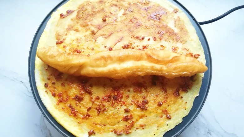 玉米渣煎饼,<a style='color:red;display:inline-block;' href='/shicai/ 580'>油条</a>从中间撕开,放一半在煎饼上面。