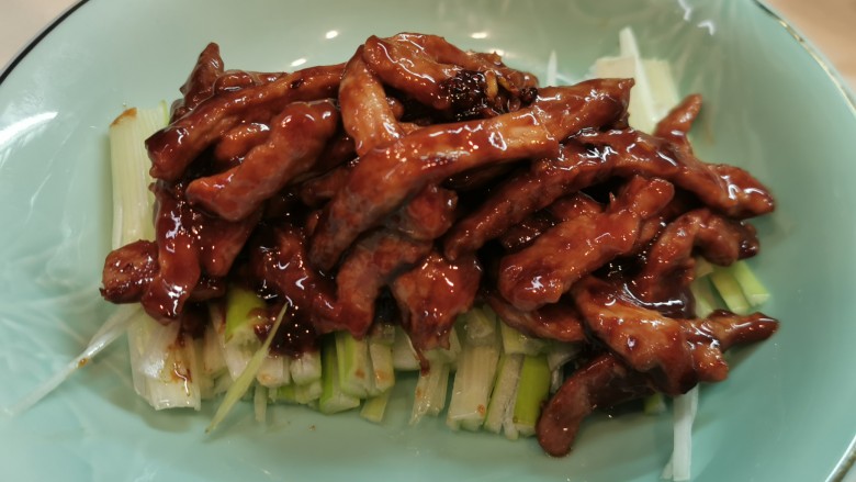 京酱肉丝,上碟享用,大葱丝垫碟底或放边上,正式的食法是配豆腐皮青瓜丝卷着吃,而我也喜欢配米饭。