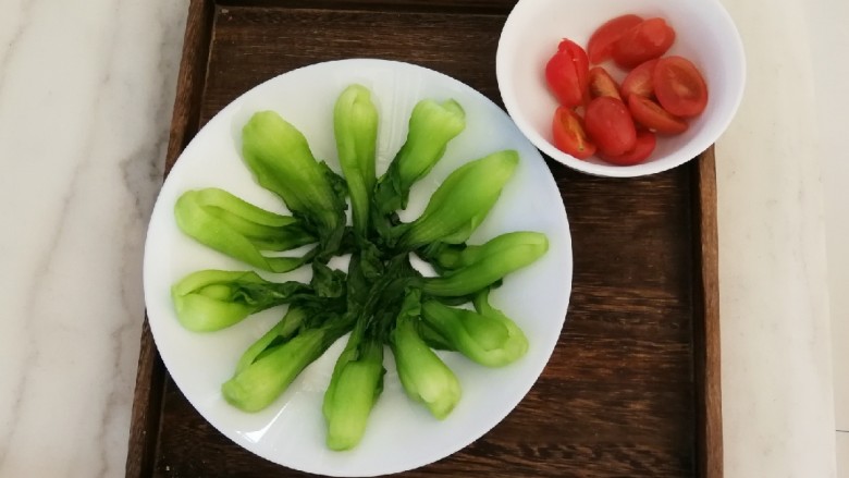 油菜炒虾仁,油菜摆入盘中 <a style='color:red;display:inline-block;' href='/shicai/ 3438'>圣女果</a>对半切开