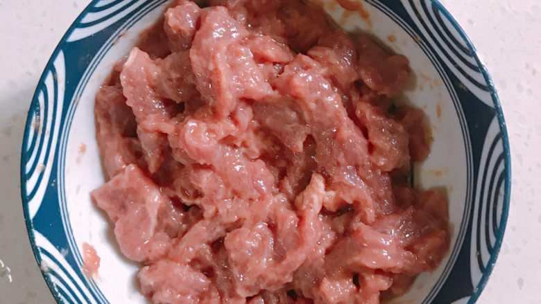 干煸牛肉丝,牛肉需要腌制。先加入少量的料酒,胡椒粉,还有生抽,用手抓住牛肉有粘稠状。然后加入少量生粉抓鱼。最后加入适量食用油腌制10分钟。