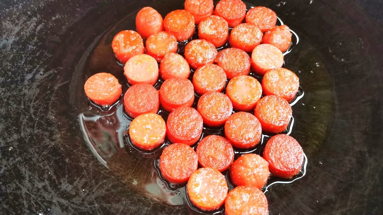 孜然火腿土豆丁,火腿肠切厚片,煎至表面微黄。