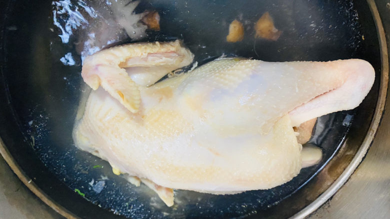 家庭版白切鸡,鸡皮全身煮缩后,盖上盖继续煮。