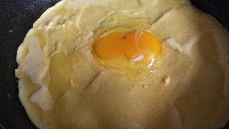 玉米渣煎饼,第二个煎饼摊好面糊很快就干了,打入一个鸡蛋摊均匀效果更佳。