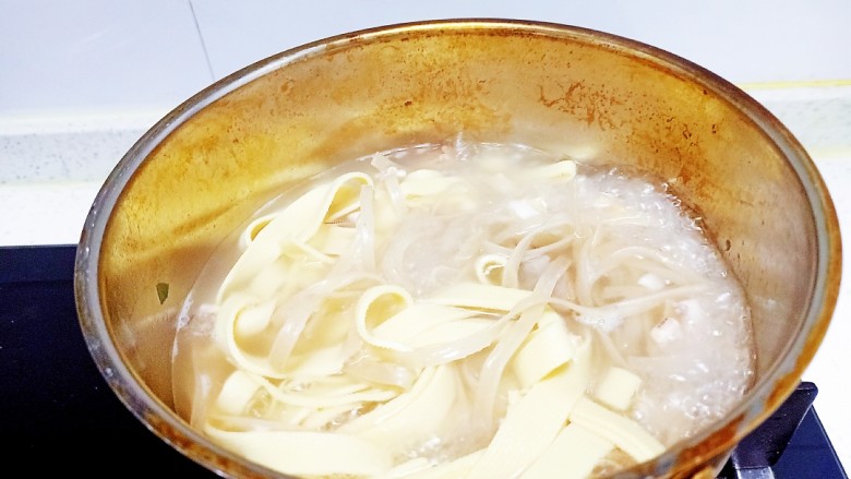 牛肉、鱿鱼炖粉条、豆腐皮,锅中放入适量清水,水开后放入鱿鱼、牛肉、红薯粉条,红薯粉条煮至断生放入豆腐皮