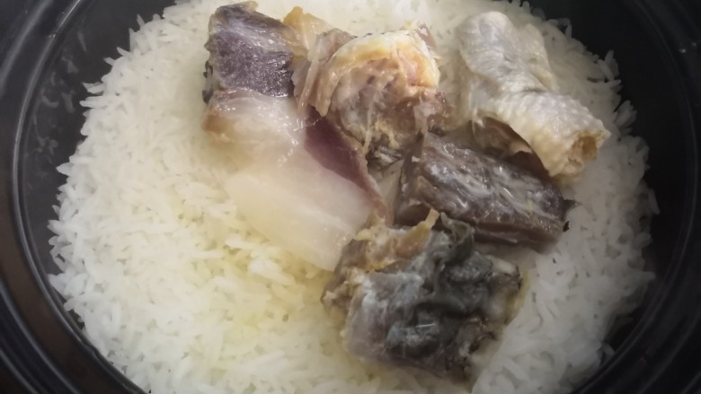 腊味煲仔饭,把洗净的<a style='color:red;display:inline-block;' href='/shicai/ 4893'>腊鱼</a>肠肉放在米饭上(小火,隔十秒左右转动下砂锅让底部受热要均匀)