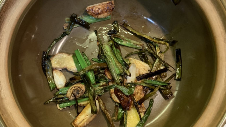 葱油焖鸡,准备好砂锅，把炒香的葱姜蒜捞出来，放入砂锅锅底，剩余的油留在平底锅里