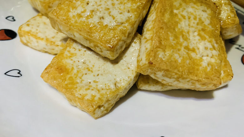 油菜豆腐,先把炸好的豆腐捞出放在盘里;