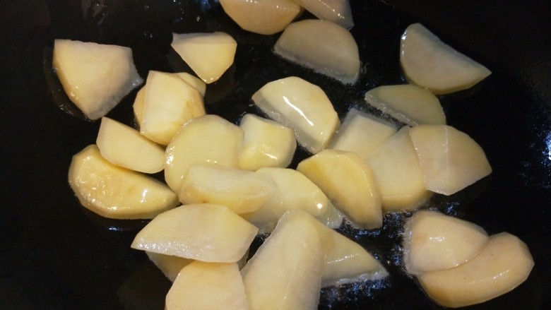 辣白菜炒土豆片,锅中倒入适量油烧热,倒入土豆片翻炒。