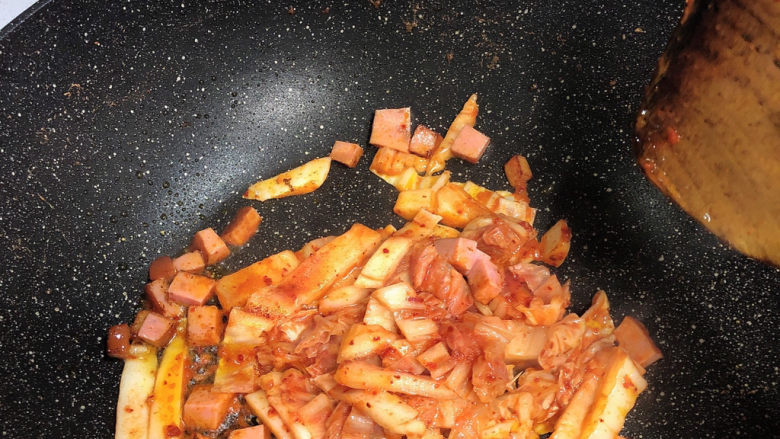 辣白菜芝士炒饭,锅里放油,根据你炒的量放,我这是一人份,所以少许。放火腿丁,<a style='color:red;display:inline-block;' href='/shicai/ 2863'>辣白菜</a>,翻炒,中火