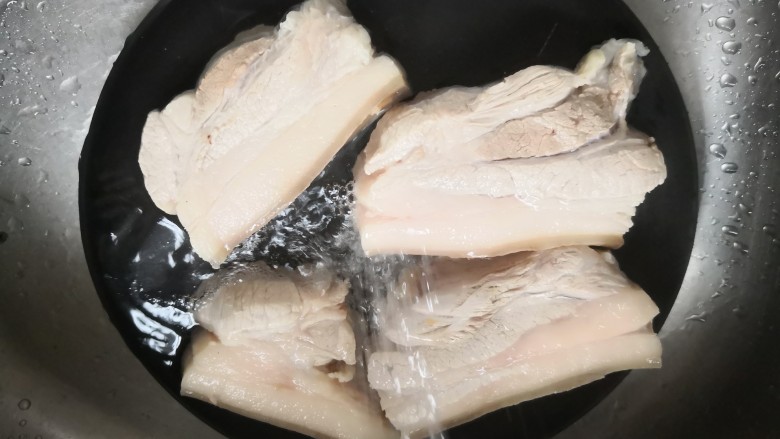 红烧五花肉,清水冲洗,去除白沫,冷水冲洗有助于肉质紧缩,口感更好。