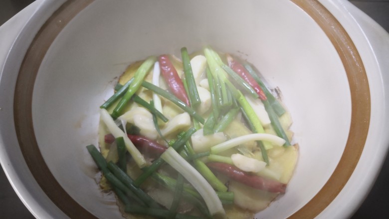 红烧五花肉,依次放入蒜、辣椒、<a style='color:red;display:inline-block;' href='/shicai/ 3250'>葱</a>段,用中小火烧热锅底,散发香味后关火。