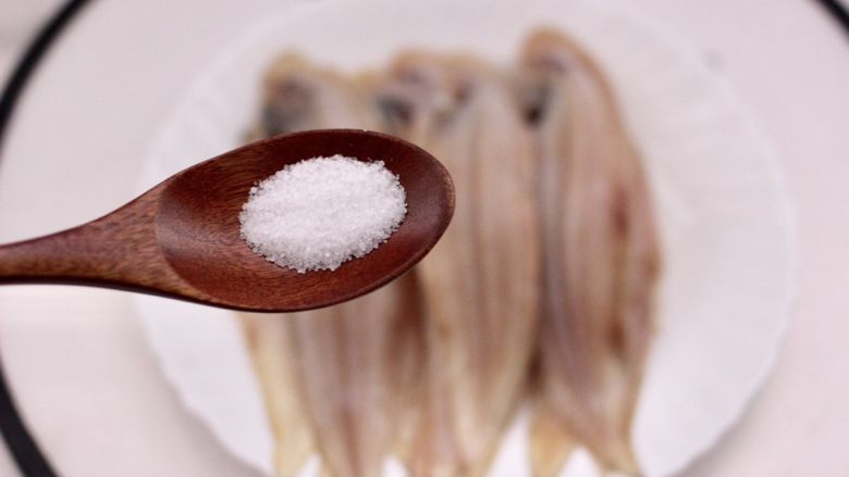 酱香辣烤舌头鱼,把洗净的舌头鱼码放在盘子里,先加入适量的盐调味。