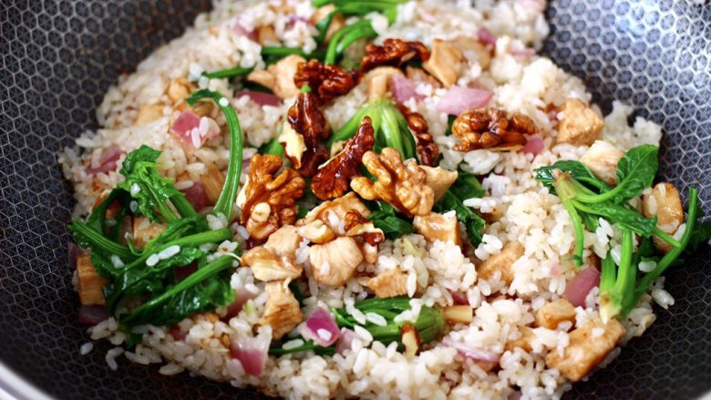 鸡丁核桃菠菜炒饭,大火翻炒均匀后,上面撒上炸香的核桃即可关火。